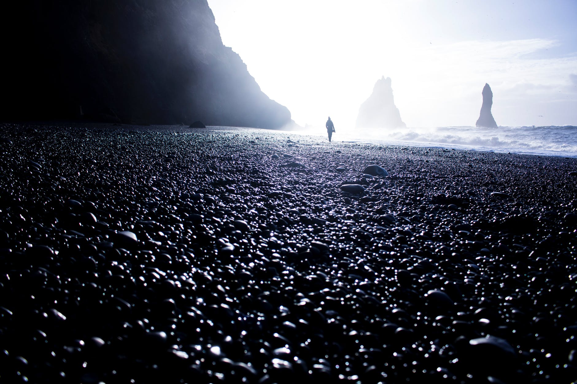 silhouette of a person standing beside seashore